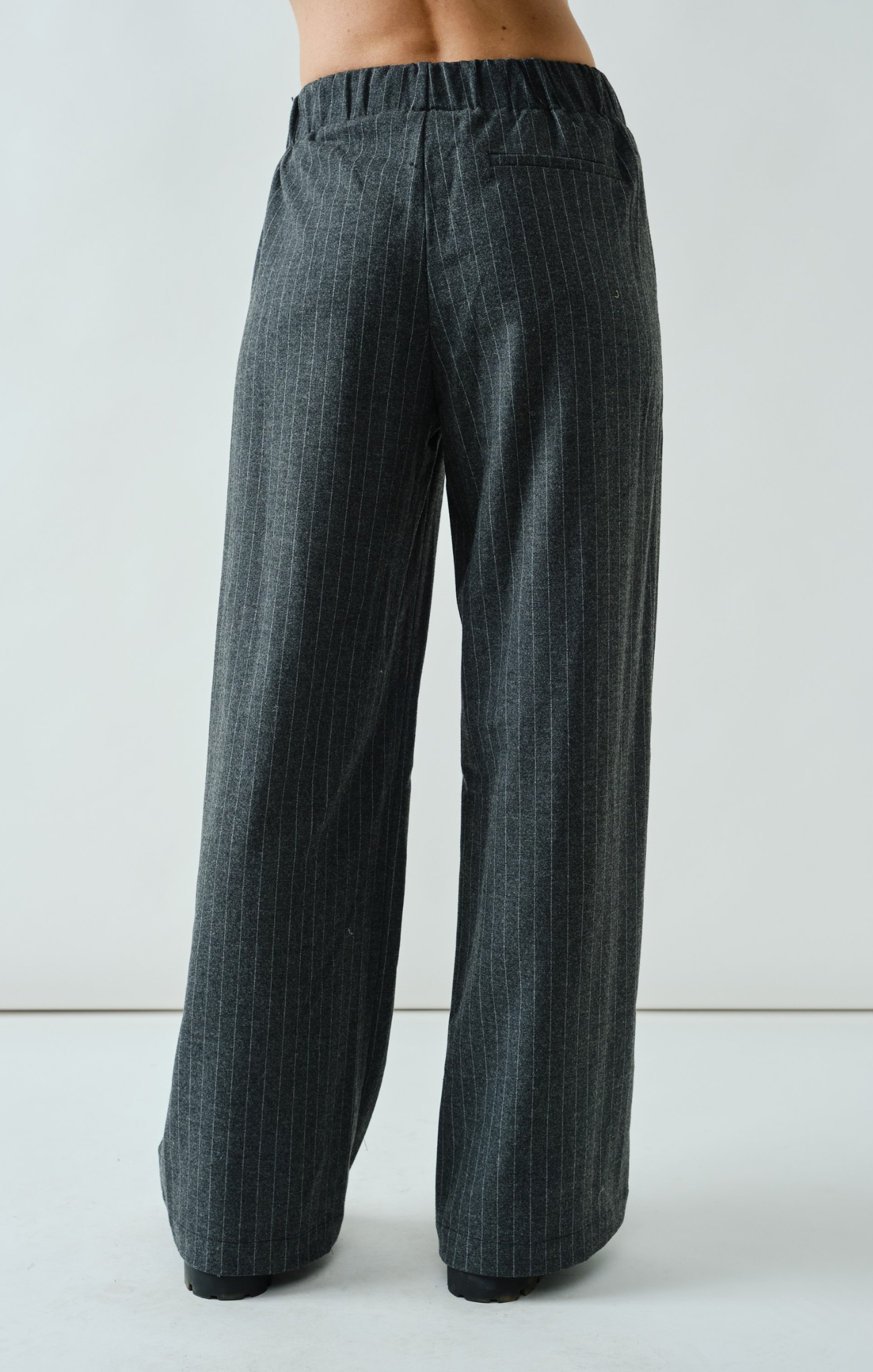 Dark plaid pants worn by a person on a white background
