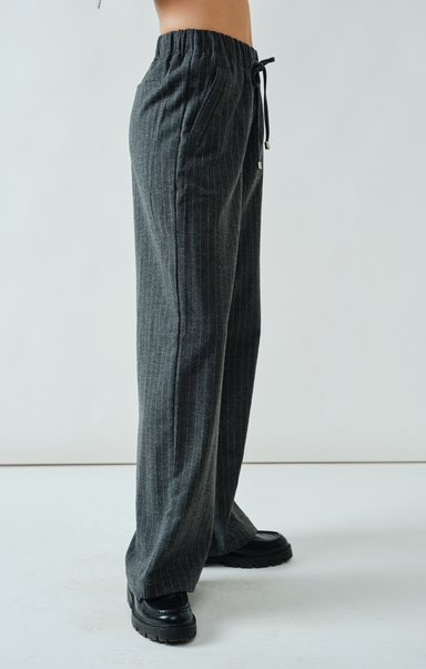 Dark gray pants with a tie waist on a white background