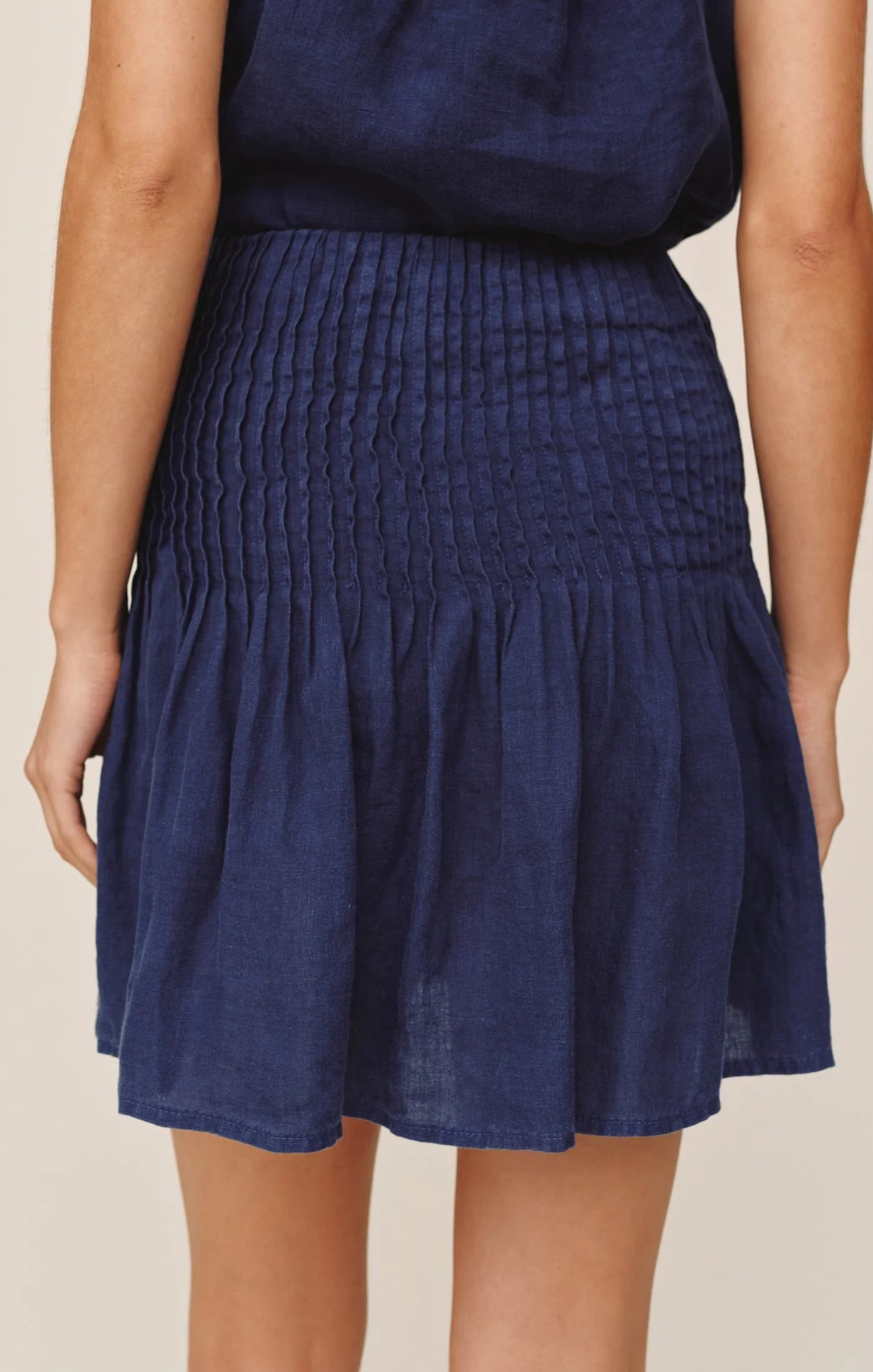 Navy blue skirt worn by a person on a beige background