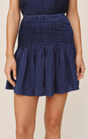 Navy blue smocked skirt worn by a person on a beige background