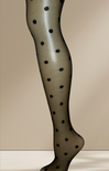 Leg wearing polka dot tights against a beige background