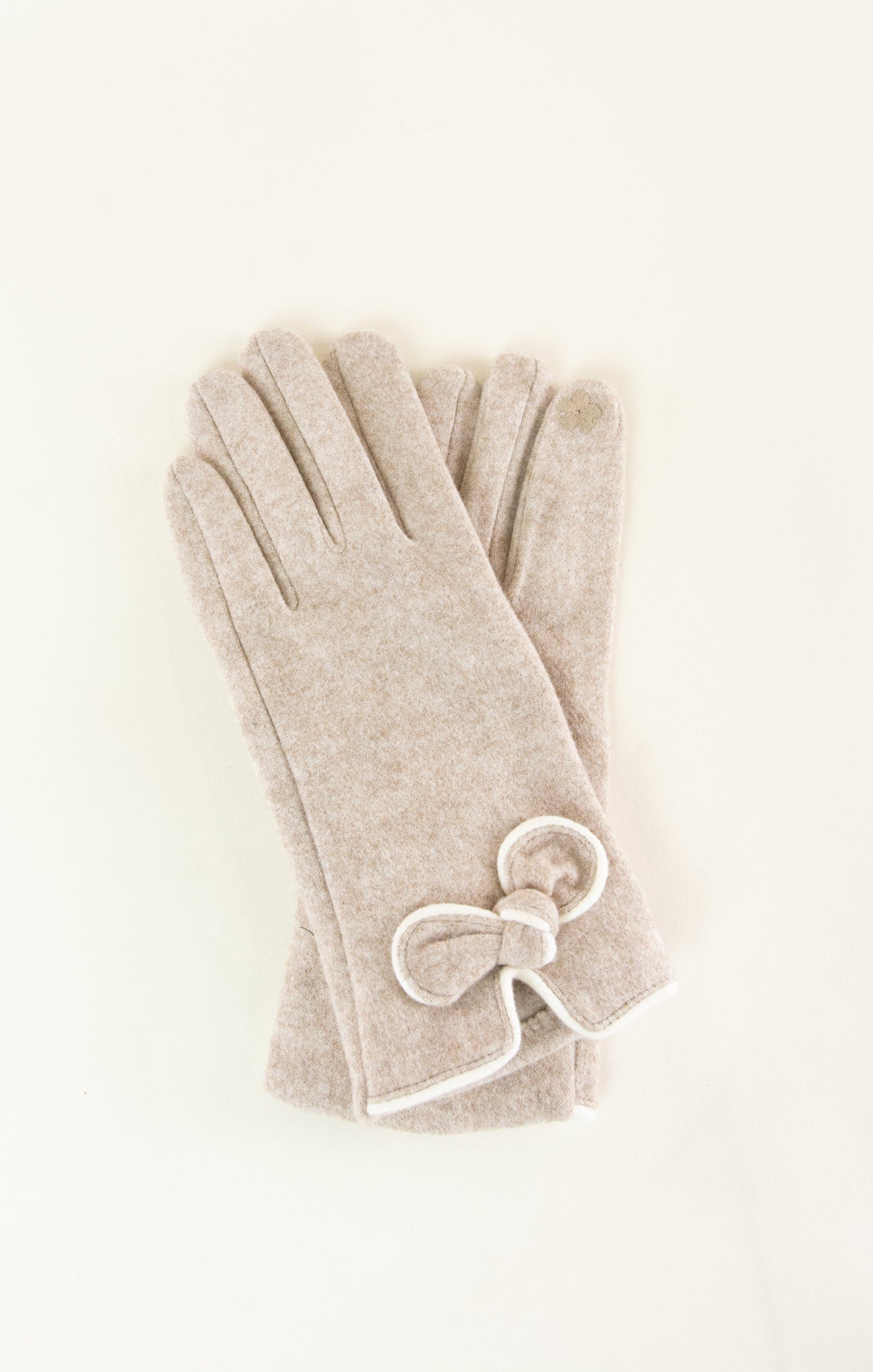 Beige gloves with a bow detail on a light beige background