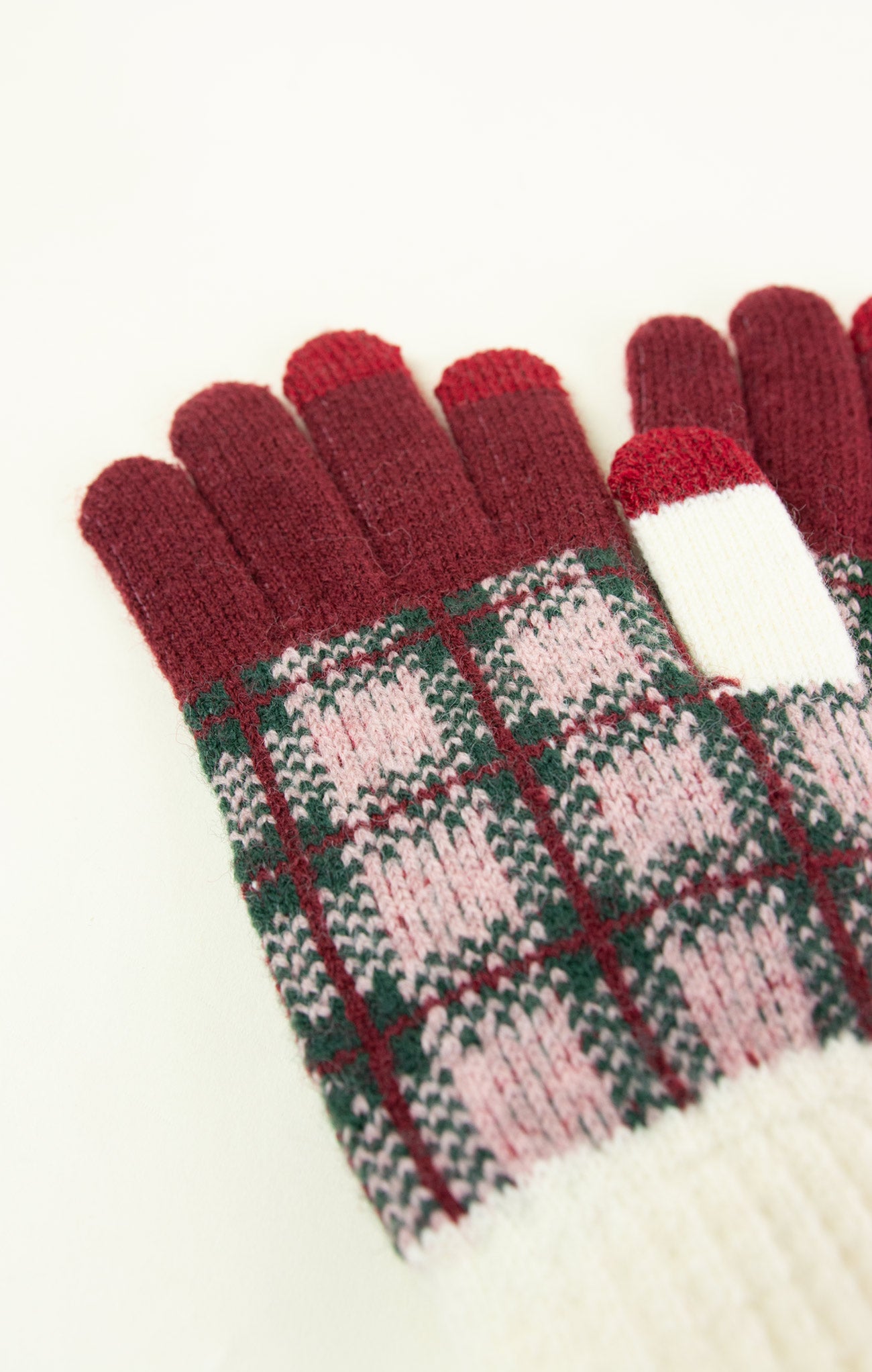 Pair of plaid gloves with red tips on a white background