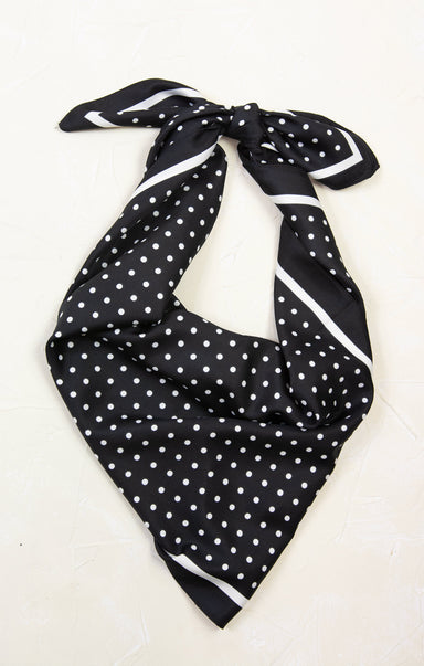 Black polka dot scarf tied on a white background