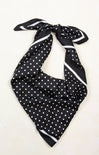 Black polka dot scarf tied on a white background