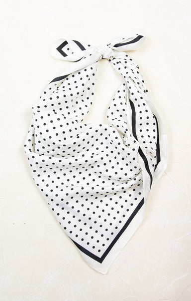White scarf with black polka dots and a bow on a white background