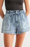 Denim shorts with a tie waist worn by a person on a plain background