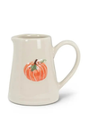 An off-white ceramic pitcher featuring a painted orange pumpkin with green leaves on the front, set against a plain white background.