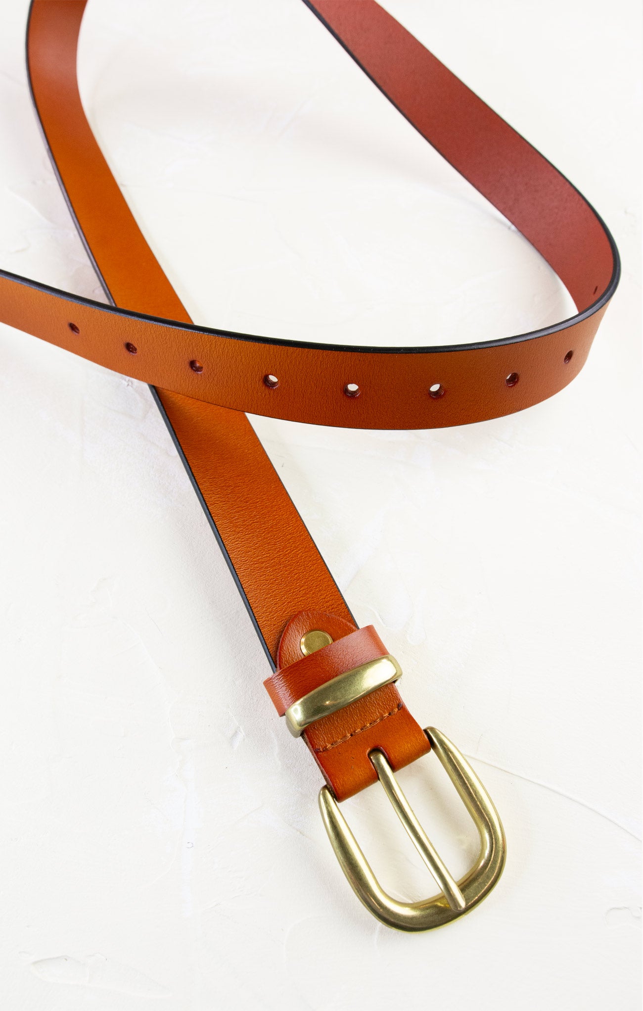 Brown leather belt with brass buckle on a white background