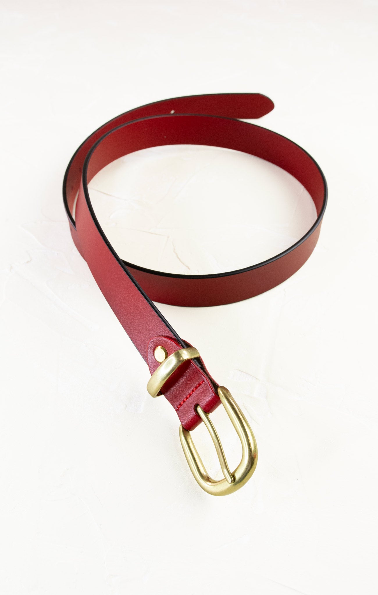 Red belt with a gold buckle on a white background