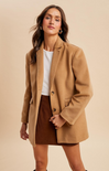 Woman wearing a brown coat and skirt on a beige background