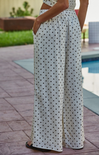 Person wearing a polka dot dress by a poolside
