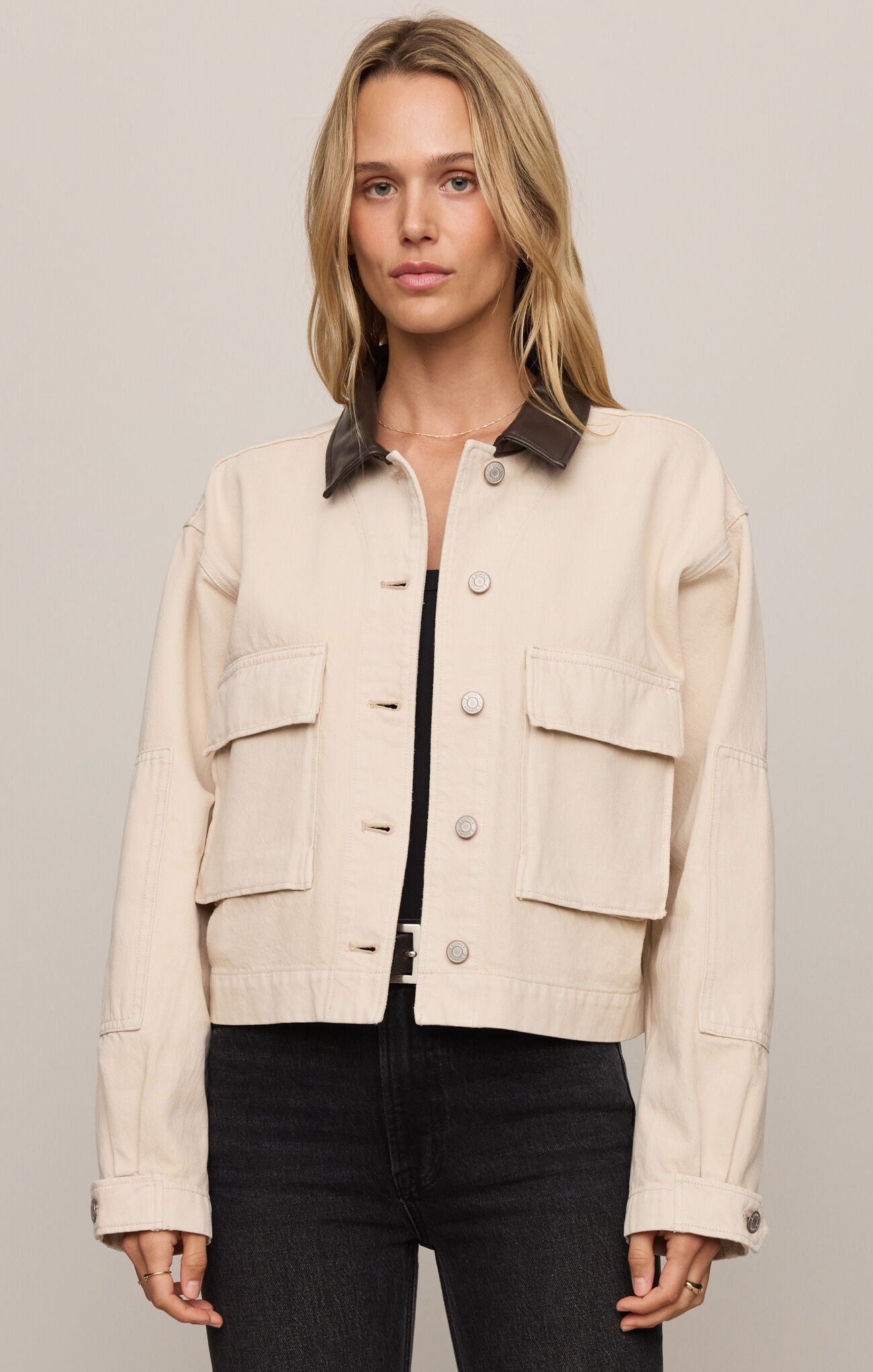 Woman wearing a beige jacket with a neutral background