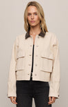 Woman wearing a beige jacket with a neutral background