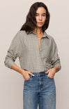 Woman wearing a plaid shirt and jeans against a plain background