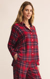 Woman wearing red plaid pajamas against a beige background