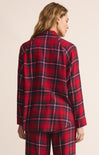 Person wearing a red plaid outfit on a beige background