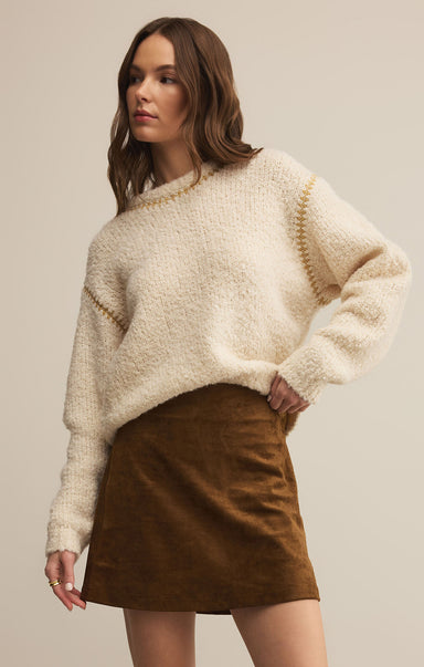 This image features the Romnie Sweater, a stylish and cozy garment perfect for casual wear. The sweater sports a soft, beige color with a plush texture, creating a warm and inviting appearance.