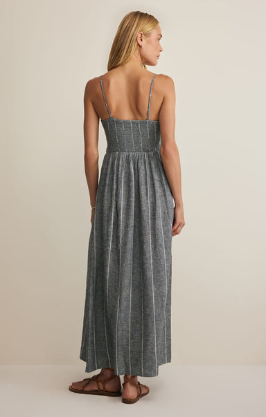 Woman wearing a gray striped dress on a beige background