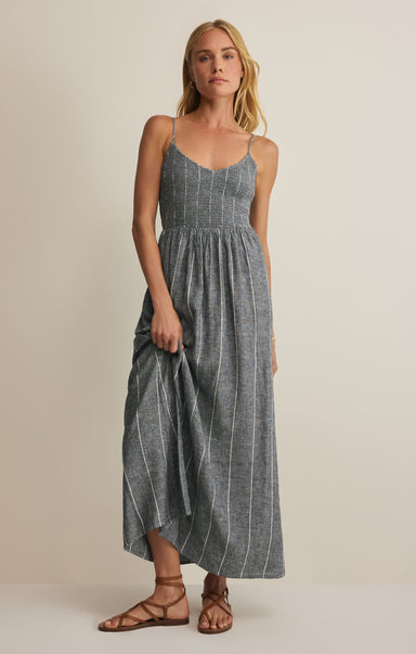 Woman wearing a gray striped dress against a beige background