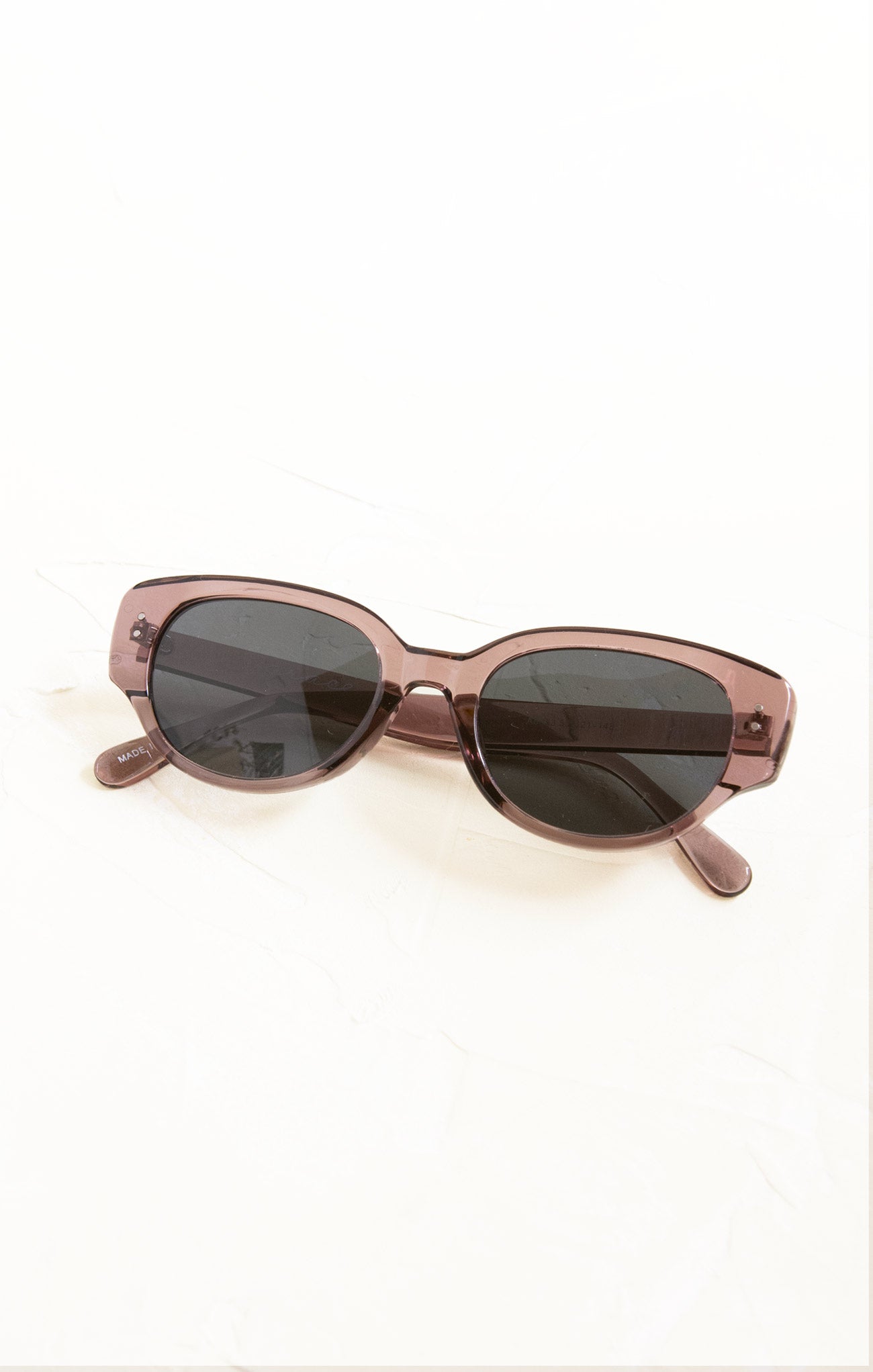 Sunglasses with a brown frame and dark lenses on a white background