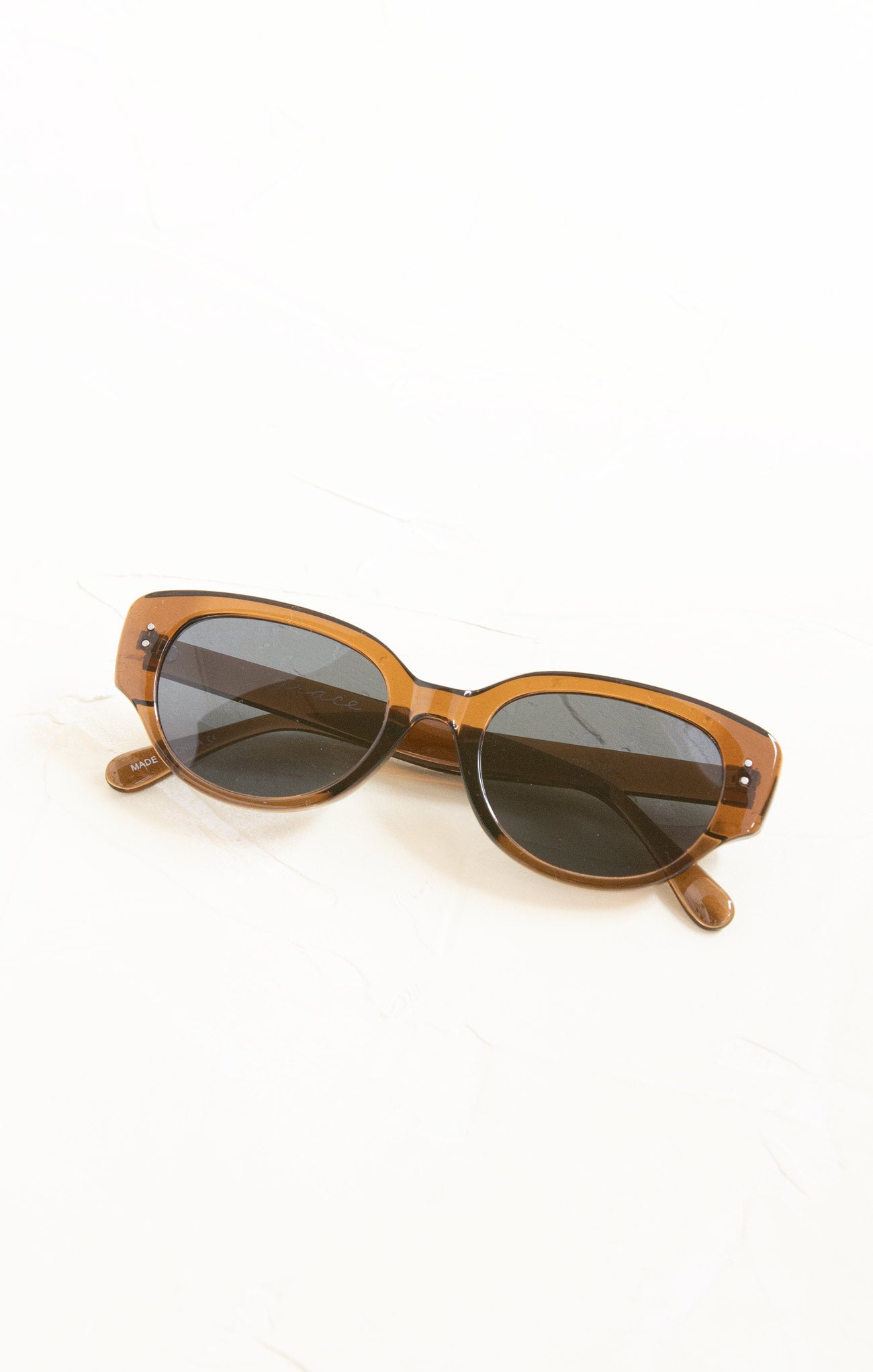 Brown sunglasses with dark lenses on a white background