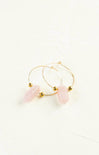 Gold hoop earrings with pink stones on a white background