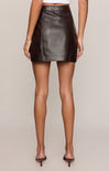 Brown leather skirt worn by a person on a beige background