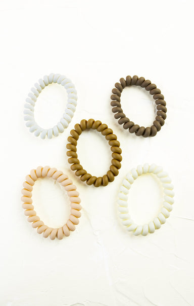 Set of five hair ties in beige, brown, and white on a white background