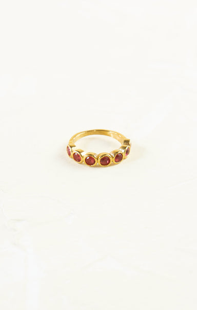 Gold ring with red stones on a white background