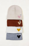 Stack of knit hats with heart designs on a white background