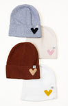 Four beanies with embroidered heart designs on a white background
