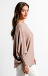 Woman wearing a light pink sweater on a white background