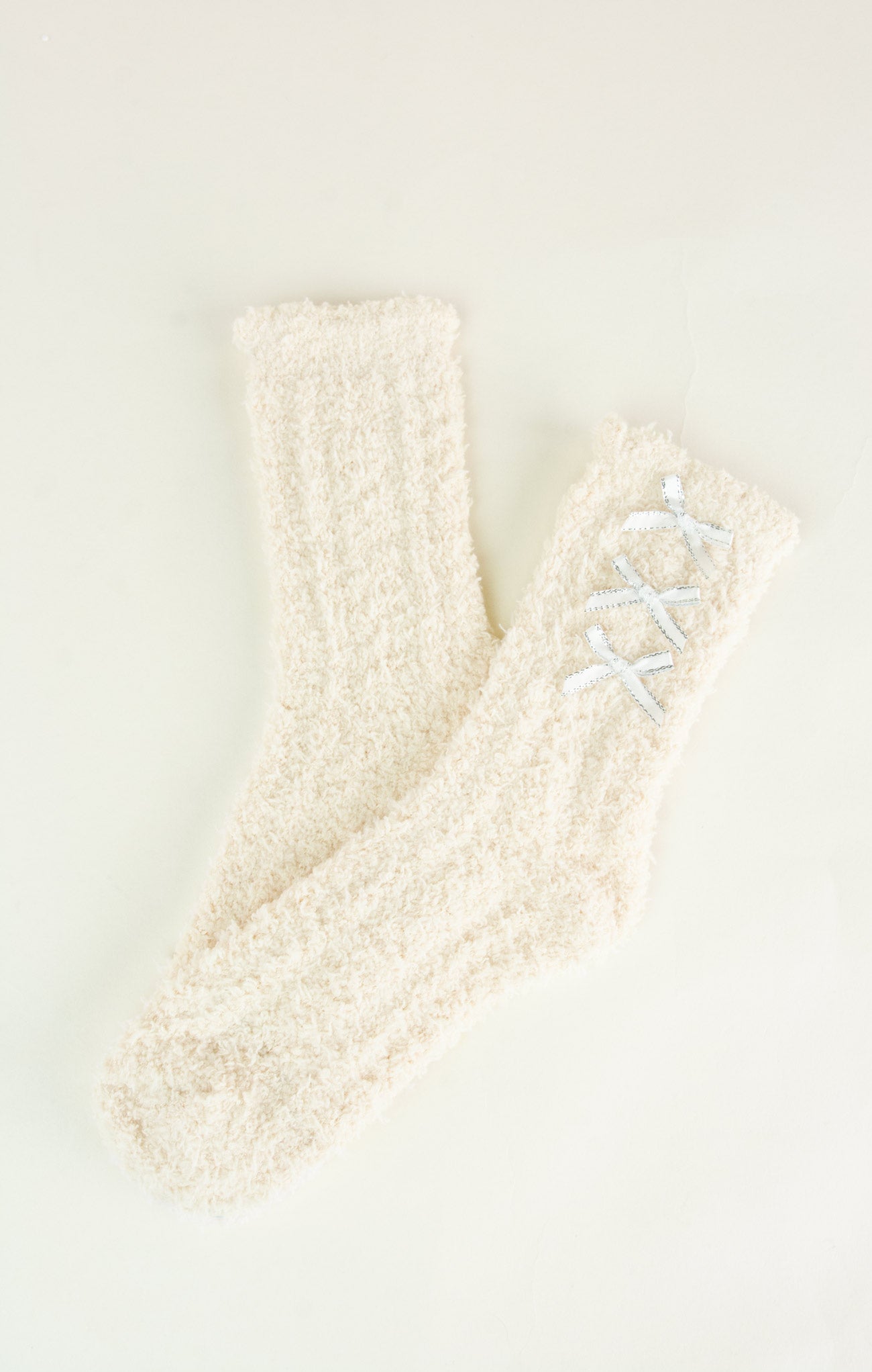Pair of cream-colored socks with a textured pattern on a light background