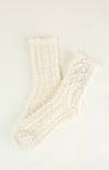 Pair of cream-colored socks with a textured pattern on a light background