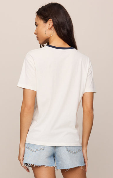 Woman wearing a white t-shirt and denim shorts on a beige background