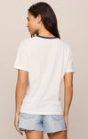 Woman wearing a white t-shirt and denim shorts on a beige background