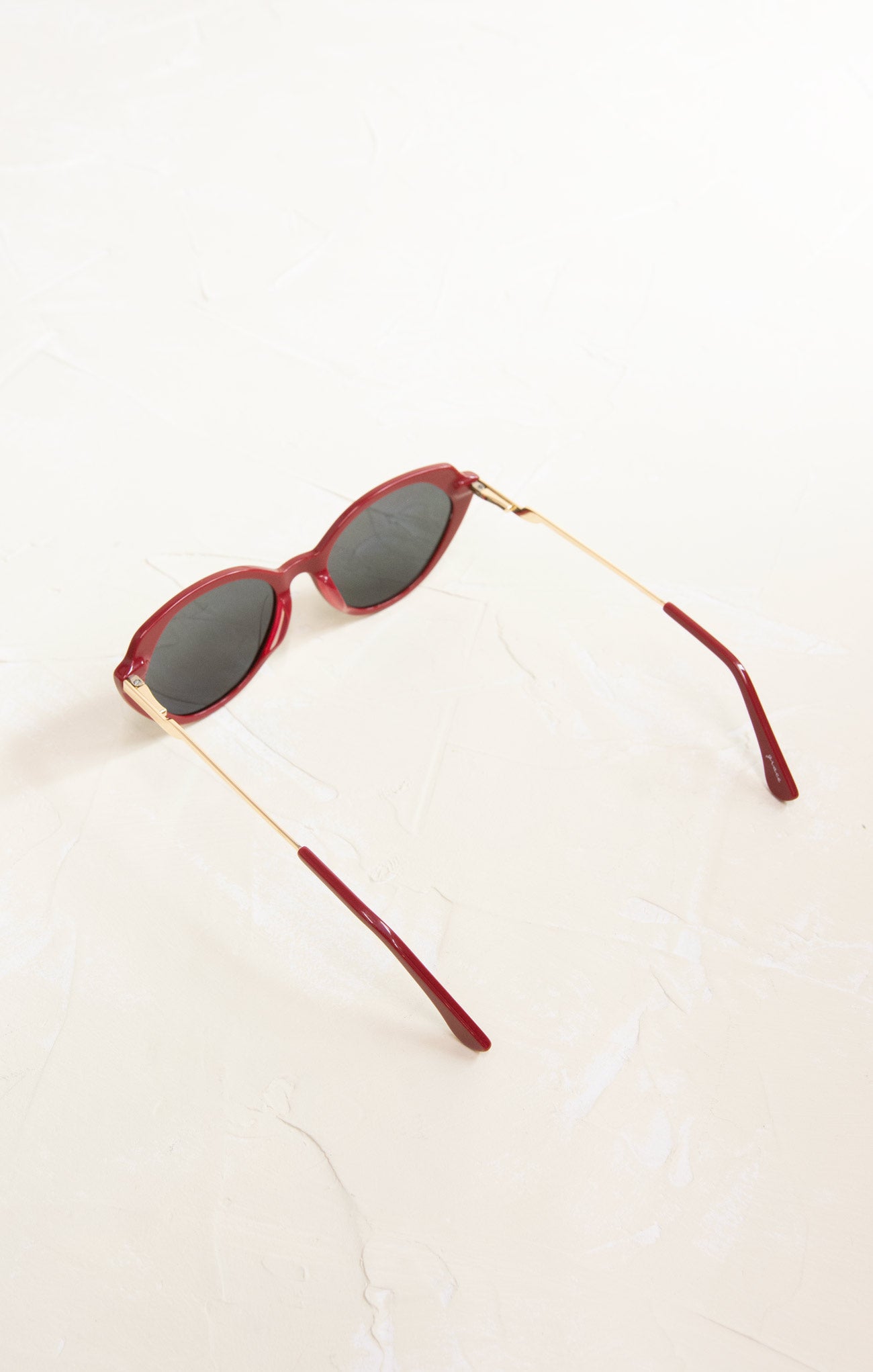 Red sunglasses with gold frames on a white background