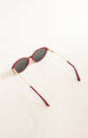 Red sunglasses with gold frames on a white background