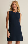 Woman wearing a navy blue dress against a beige background