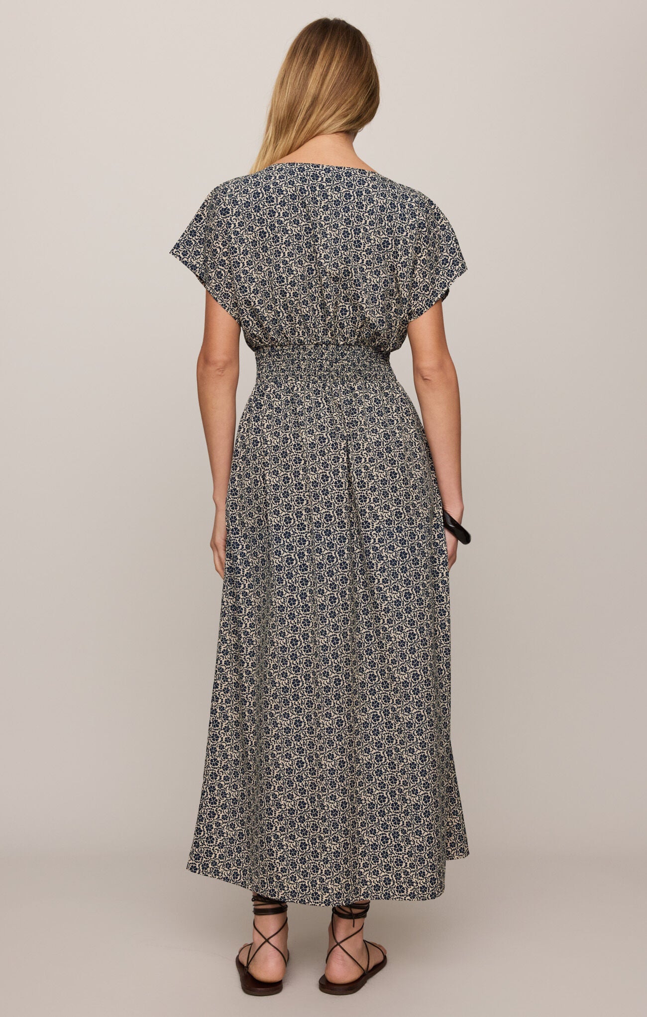 Woman wearing a patterned dress on a plain background