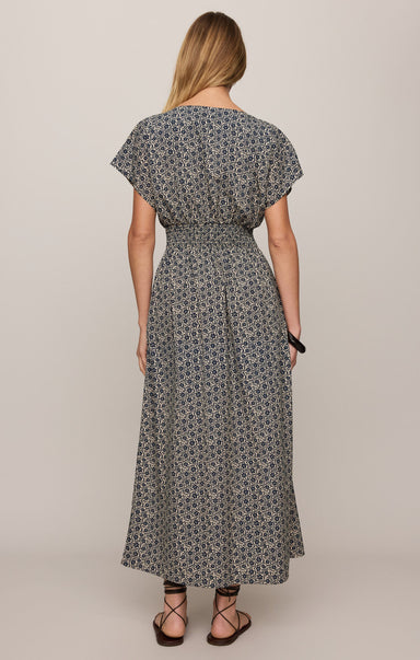 Woman wearing a patterned dress on a plain background