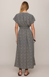 Woman wearing a patterned dress on a plain background