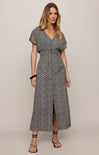 Woman wearing a gray patterned dress on a plain background