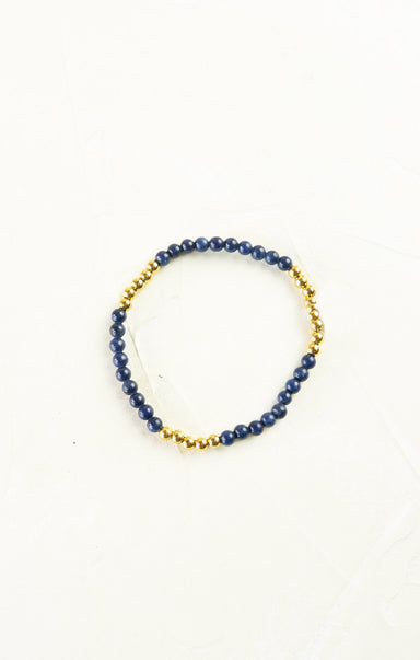 Bracelet with blue beads and gold accents on a white background