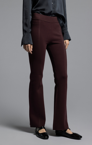 Person wearing a dark shirt and brown pants on a gray background