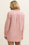 Person wearing a red and white striped shirt against a beige background