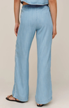 Light blue denim pants worn by a person on a beige background