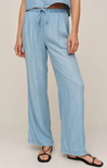 Light blue denim pants worn by a person on a beige background