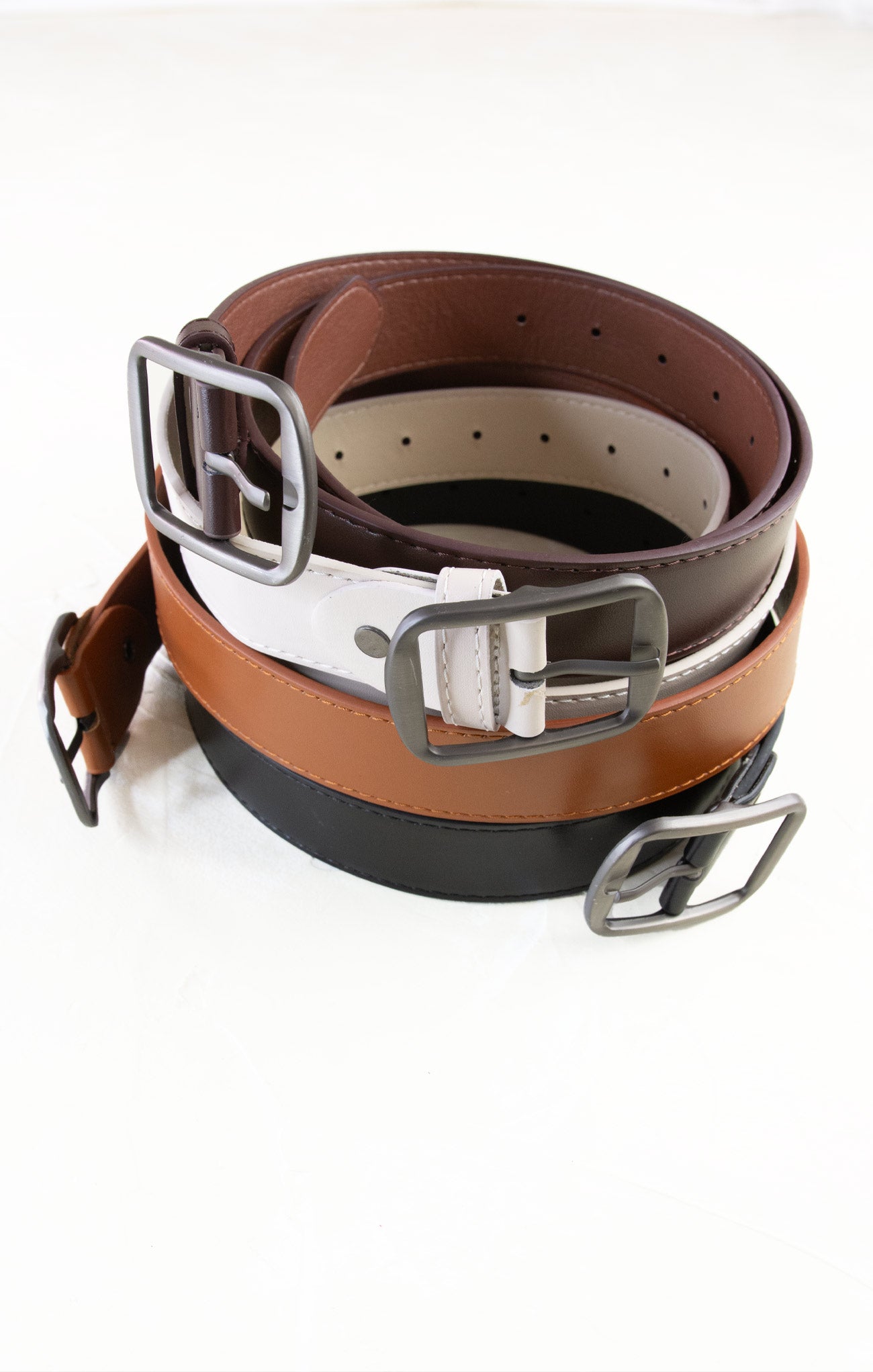 Three leather belts with metal buckles on a white background